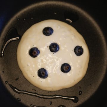 Process Shot: pancake in pan with blueberries on top